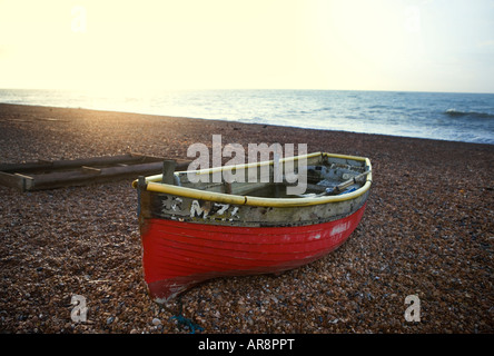 Rosso barca da pesca su una spiaggia di ciottoli nel Regno Unito Foto Stock