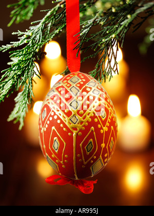 Tradizionale festivo decorato Natale bauble appeso su un albero di Natale con luci dietro Foto Stock