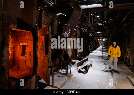 Esploratore urbano nella coperta di neve abbandonato Don Valley laterizi impianto Toronto con il fuoco nel forno del forno Foto Stock