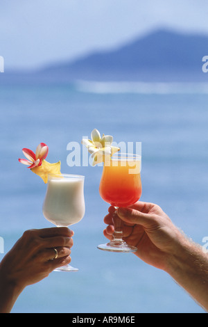 Coppia in vacanza isola la tostatura con bevande tropicali Foto Stock