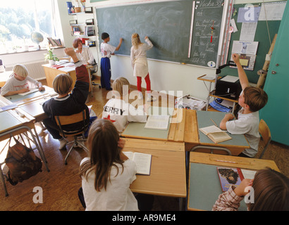 Gli studenti nel quinto grado classe svedese scrivere sulla lavagna durante la sessione di domande e risposte Foto Stock