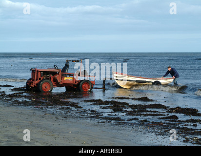 Fisherman alaggio barca usando il vecchio Land Rover e telaio rimorchio dal Mare del Nord al Boulmer Northumberland England Regno Unito Foto Stock