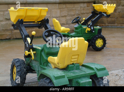 Bambini i trattori giocattolo sul bagnato a Alnwick Gardens Northumberland England Regno Unito Regno Unito Foto Stock