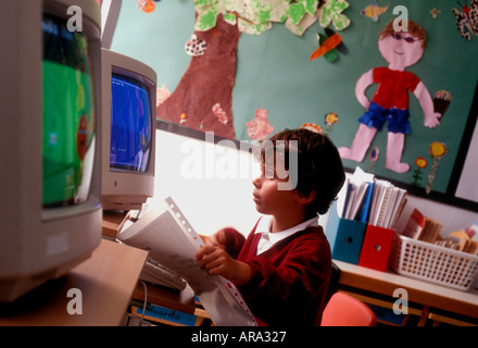 Schermo del computer degli anni '90 ragazzo della scuola infantile di età compresa tra 3 e 5 anni a schermo del computer con opere d'arte in background prime lezioni di computer infantile negli anni '90 Foto Stock