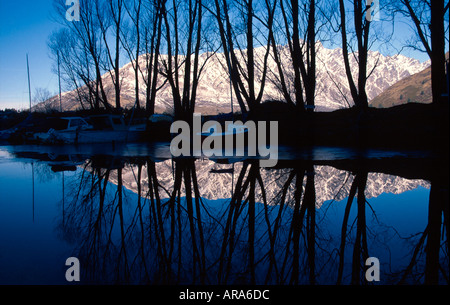 Neve sui Remarkables e silhouette di alberi Frankton Marina Lago Wakatipu Queenstown Isola del Sud della Nuova Zelanda Foto Stock