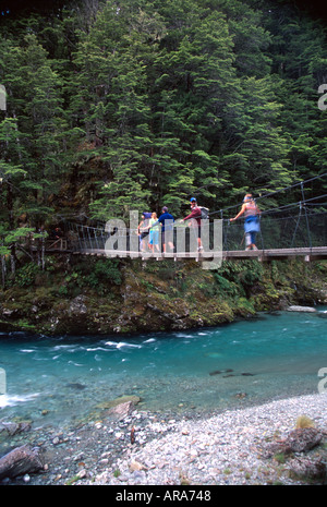 Trampers su swingbridge su percorso masterizzare Routeburn via Mt Aspiring National Park Isola del Sud della Nuova Zelanda Foto Stock