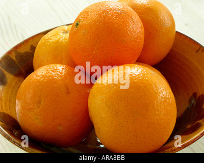Vaso in ceramica con cinque arance fresche Foto Stock