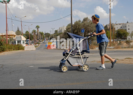 Giovani coloni ebrei di spingere un passeggino nell'insediamento israeliano di Kiryat Arba o Qiryat Arba a Hebron Cisgiordania Israele Foto Stock