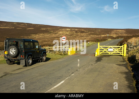 Land Rover dalla griglia di bestiame su hill road Foto Stock