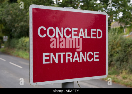 Attenzione nascosto entrance road sign Foto Stock