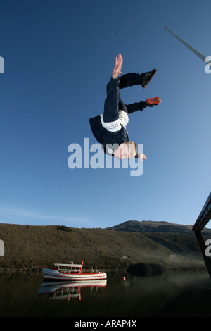 Un Parkour Freerunner backflips fuori di una sporgenza con una barca in background, prese a Llanberis, il Galles del Nord. Foto Stock