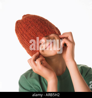 Adolescente tirando Hat sopra la testa Foto Stock