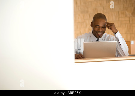 African- impresario americano lavora sul computer portatile. Foto Stock