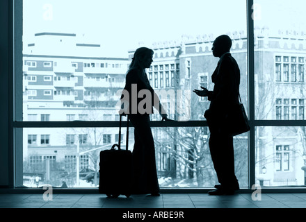 Due colleghi di lavoro stagliano in una grande finestra. Foto Stock