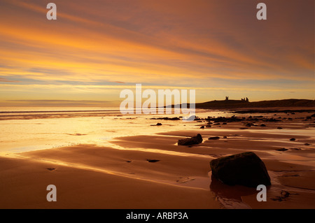 Il castello di Dunstanburgh Embleton Beach all'alba Northumbria England Regno Unito Foto Stock