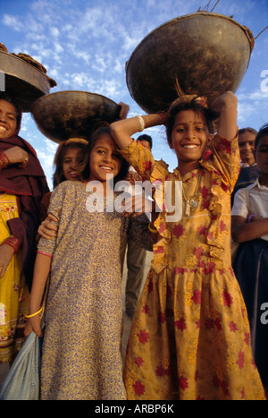 Le donne e i bambini la raccolta del letame per i loro fuochi, nei pressi di Khimsar, Rajasthan, India Foto Stock