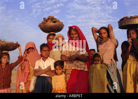 Le donne e i bambini la raccolta del letame per i loro fuochi, nei pressi di Khimsar, Rajasthan, India Foto Stock