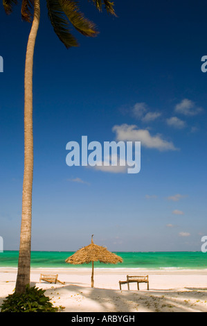 Con tetto di paglia di un ombrellone e lettini tradizionali realizzati dal legno di noce di cocco, Paje Beach, Zanzibar, Tanzania, Africa orientale, Africa Foto Stock