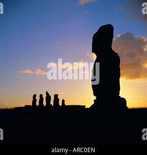 Silhouette di Ahu Tahai in primo piano e dietro i cinque moai (statue) di Ahu Vai Uri, Isola di Pasqua, Cile Foto Stock