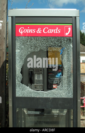 Villaggio chiamata payphone casella che si trova al di fuori di public house con soggetto ad atti vandalici pannelli di vetratura Foto Stock