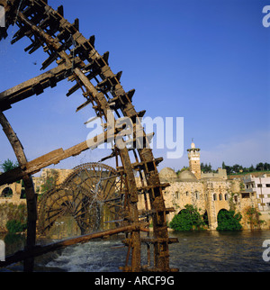 Waterwheels (norias) sul fiume Oronte, Moschea al di Nuri sulla riva lontana, Hama, Siria, Medio Oriente Foto Stock