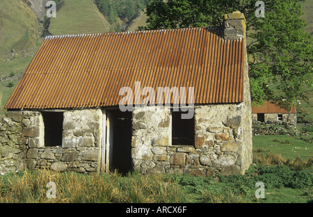 Cottage in pietra con rusty ferro corrugato tetto Foto Stock