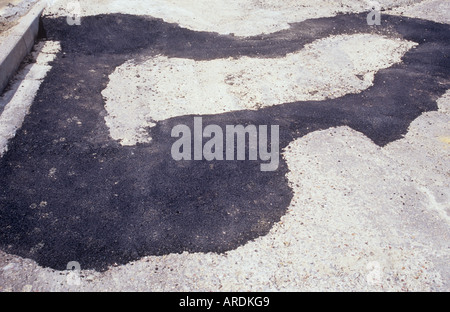 Dettaglio di un piccolo tratto di strada asfaltata e frenare con il quale è stato patchato con nuovo asfalto nero Foto Stock