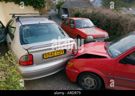 Bere Collisione azionamento su strette strade di campagna tra due vetture red fiesta nel retro del argento parcheggiata Rover liquidarla in Inghilterra Foto Stock