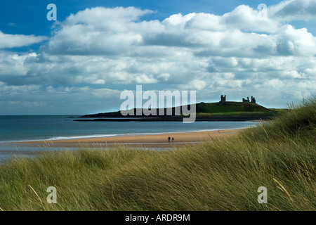 Un paio di passeggiate lungo la spiaggia di Embleton, Northumberland, Regno Unito verso la lontana sagoma del Castello Dunstanburg Foto Stock