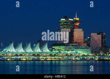 Canada Place Cruise Ship Terminal con lo skyline di Vancouver in background al crepuscolo. Foto Stock