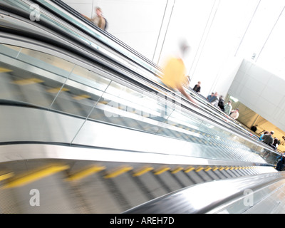 Aeroporto patroni cavalcare le scale mobili tra il terminale cancelli e trasporto a terra all'Aeroporto Internazionale di Dulles Foto Stock