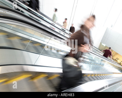 Aeroporto patroni cavalcare le scale mobili tra il terminale cancelli e trasporto a terra all'Aeroporto Internazionale di Dulles Foto Stock