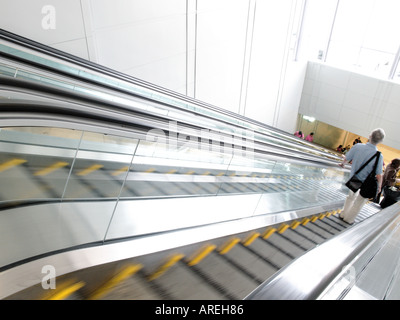 Aeroporto patroni cavalcare le scale mobili tra il terminale cancelli e trasporto a terra all'Aeroporto Internazionale di Dulles Foto Stock