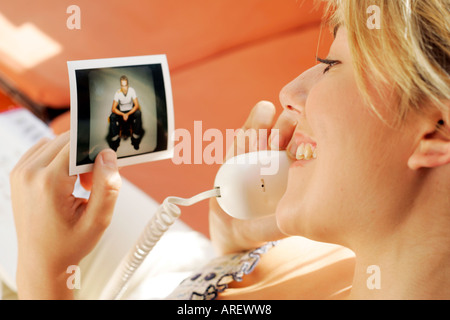 Giovane ragazza in chat su telefono guardando fotografia Foto Stock