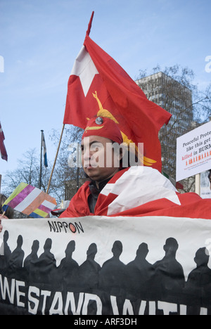 L uomo indossa rosso aveva birmano e porta e indossa bandiera dietro banner all inizio della Birmania la pace cammina, Londra, 5 gennaio, 2008 Foto Stock