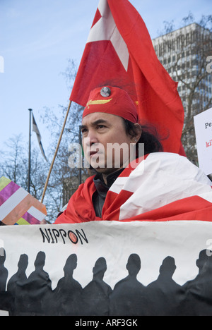 L uomo indossa rosso aveva birmano e porta e indossa bandiera dietro banner all inizio della Birmania la pace cammina, Londra, 5 gennaio, 2008 Foto Stock