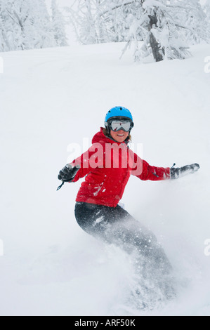 Idaho. Un felice snowboarder gode di una polvere fresca giornata in montagna. Foto Stock