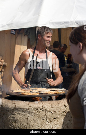 Pane tradizionale rendendo su un fuoco aperto a viking rievocazione festival in Danimarca Foto Stock