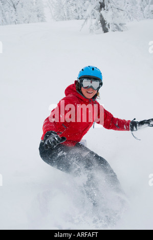 Idaho. Un felice snowboarder gode di una polvere fresca giornata in montagna. Foto Stock