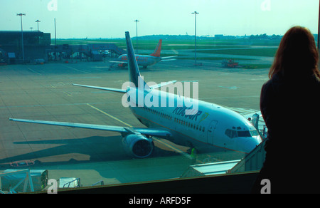 Holiday Maker in aeroporto in attesa di piano della scheda Foto Stock