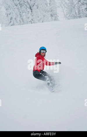 Idaho. Un felice snowboarder gode di una polvere fresca giornata in montagna. Foto Stock