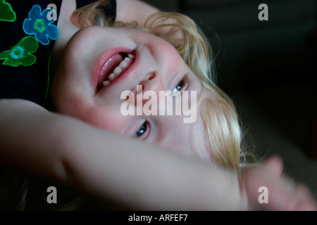 Ragazza bionda appeso a testa in giù e ridere Foto Stock