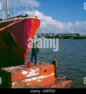 L'uomo pittura sulla prua di un impianto di trivellazione petrolifera imbarcazione di appoggio cantiere di riparazione navale, Grimsby, Humberside, North Lincolnshire, Inghilterra, Regno Unito. Foto Stock