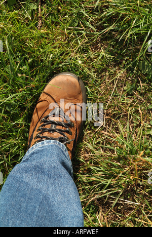 Close up di un uomo a piedi di boot mid-stride Foto Stock