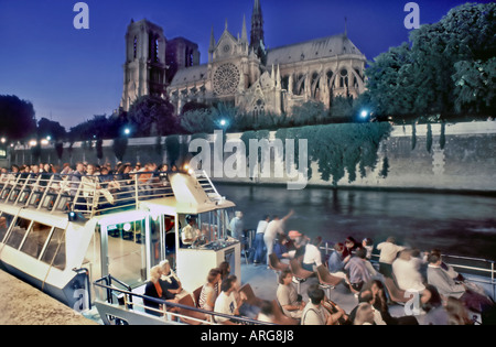 Parigi Francia ormeggiati Peniche sul Fiume Senna "Bateau Mouche' imbarcazione turistica illuminata di notte nei pressi di "Notre Dame", di notte Foto Stock