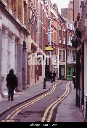 Doppio giallo linee passanti attraverso strette e tortuose strade medievali di Blackfriars con persona in movimento sfocate, City of London Foto Stock