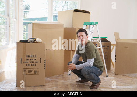 Uomo in casa con scatole di cartone Foto Stock