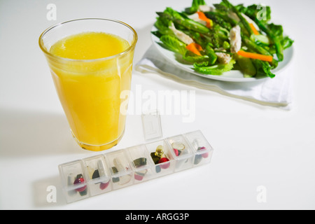 Insalata di pollo, succo d'arancia e l'erogatore di pastiglia Foto Stock