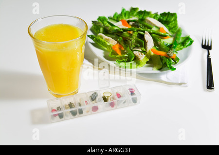 Insalata di pollo, succo d'arancia e l'erogatore di pastiglia Foto Stock