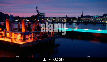 Berlino. Badeschiff an der Arena am Abend. Badeschiff in serata. La gente di nuoto, rilassarsi e godersi il tramonto e lo skyline. Foto Stock